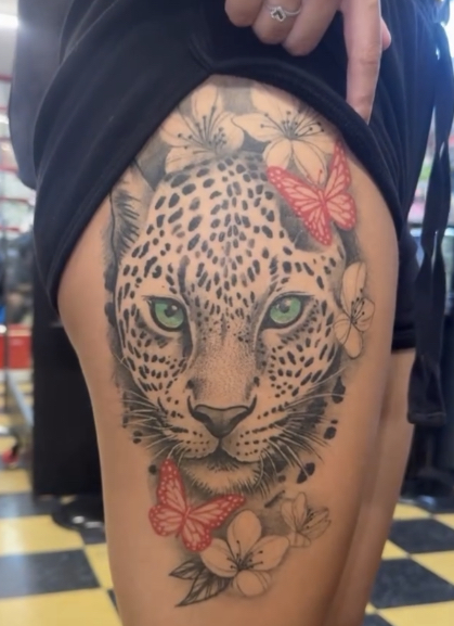 Leopard with red butterflies thigh tattoo